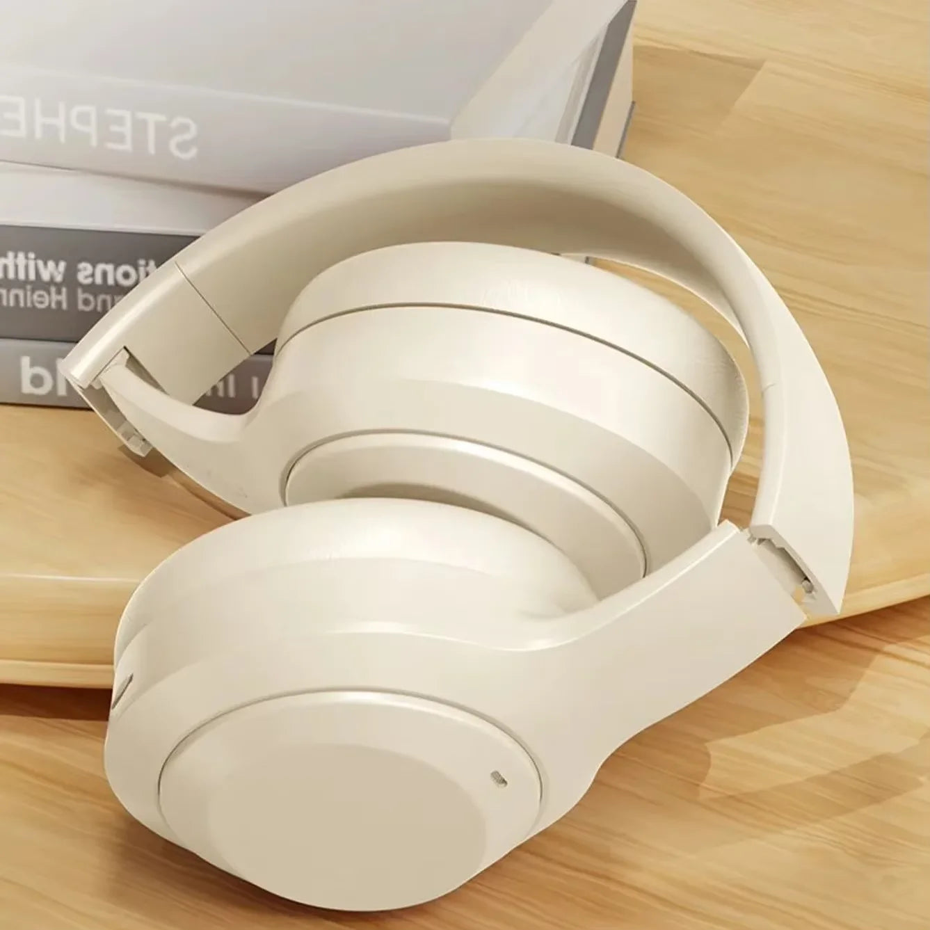 Beige headphones on a wooden surface with a blurred background